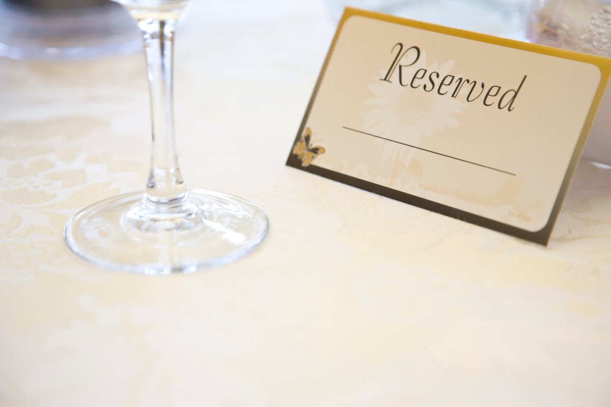 Place setting and reserved sign on restaurant table.