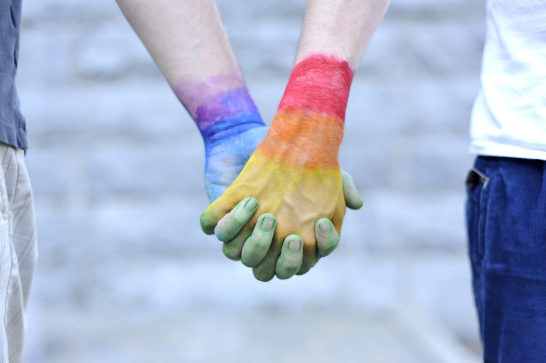 Two gay men holding their hands painted with the colors of the LGBT movement on May 24, 2012.