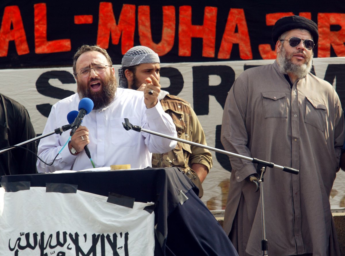 Radical muslim clerk Sheikh Omar Bakri Muhammad (L) gestures while addressing devotees as fellow clergyman Sheikh Abu Hamza (R) waits his turn at the "Rally for Islam" at  Trafalgar Square in central London, 25 August 2002. Some 400 hundred Al-Muhajiroun supporters gathered for  the rally as British nationalists staged a counterdemonstration causing minor scuffles with police separating the two groups. 
