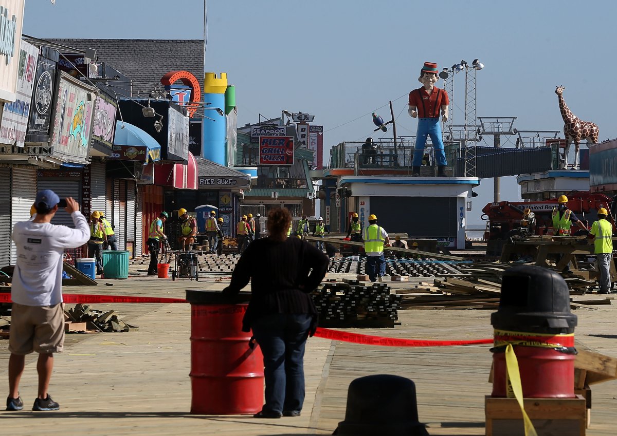 People watch as workers continue to install the new boardwalk that was damaged six months ago by Superstorm Sandy May 4, 2013 in Seaside Heights, New Jersey. Seaside Heights Mayor Bill Akers said parts of the two mile long boardwalk are completed and he is confident its entirety will be completed when the beaches opens on Memorial Day weekend.