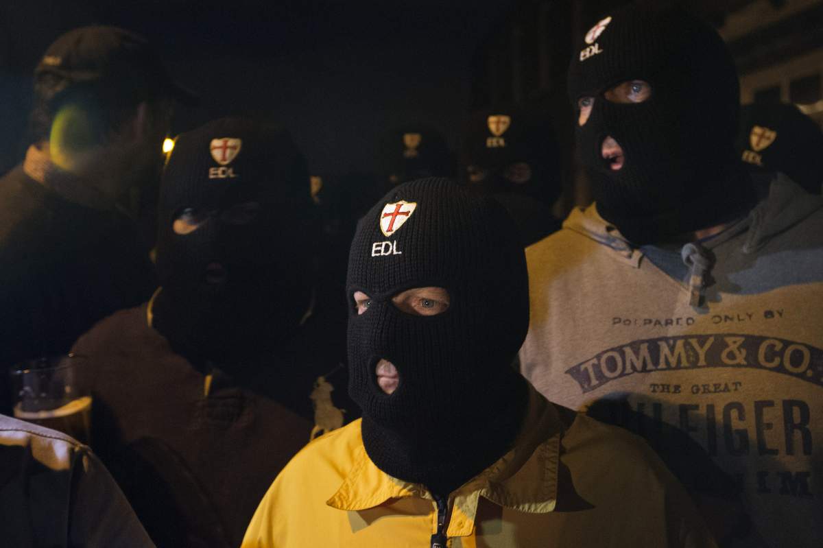 Members of the English Defence League (EDL) wear balaclavas as they gather outside a pub in Woolwich in London on May 22, 2013 after a man believed to be a serving British soldier was brutally murdered nearby in what Prime Minister David Cameron said appeared to be a terrorist attack. A man believed to be a British soldier was brutally murdered by suspected Islamists near a London barracks in an attack Prime Minister David Cameron said appeared to be terror-related.Cameron called the attack “appalling”, and said: “There are strong indications that it is a terrorist incident.” Photo: Justin Tallis (AFP)/Getty Images