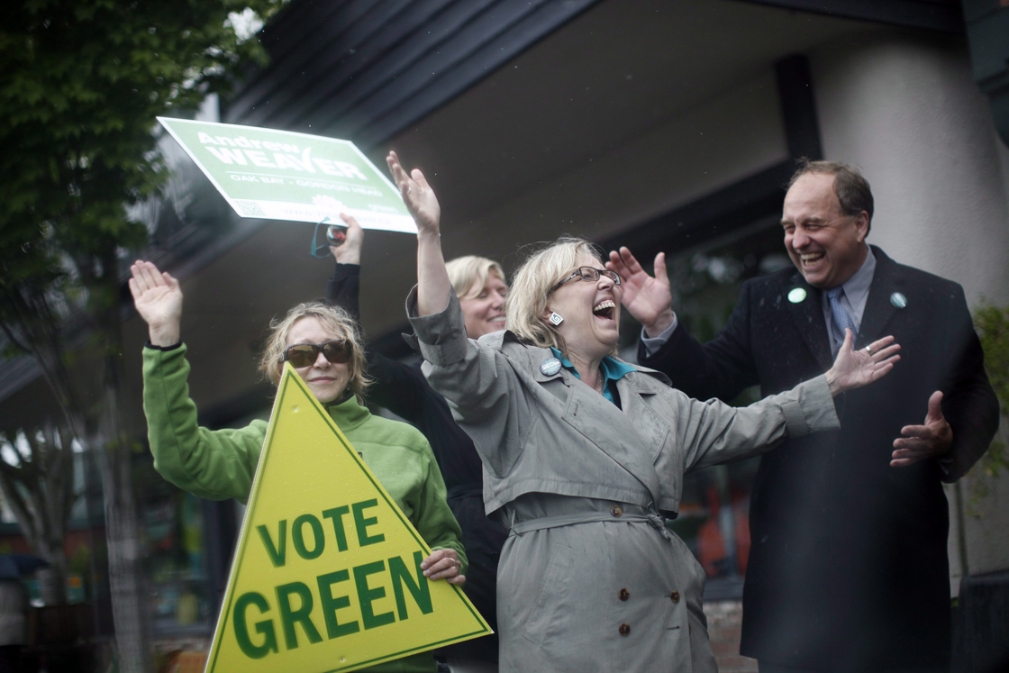 Federal Green Party leader Elizabeth May and Oak Bay/Gordon Head B.C. Green Party MLA candidate Andrew Weaver brave the elements to wave at traffic and speak to people along Oak Bay Ave. and Monterrey Ave. in Victoria Monday May 13, 2013. 