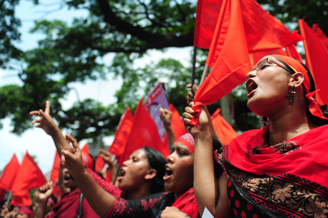 Bangladeshi activists shout slogans and wave flags during a procession to mark May Day or International Workers Day in Dhaka on May 1, 2013. Tens of thousands of Bangladeshis joined May Day protests Wednesday to demand the execution of textile bosses over the collapse of a factory complex, as rescuers warned the final toll could be more than 500. 