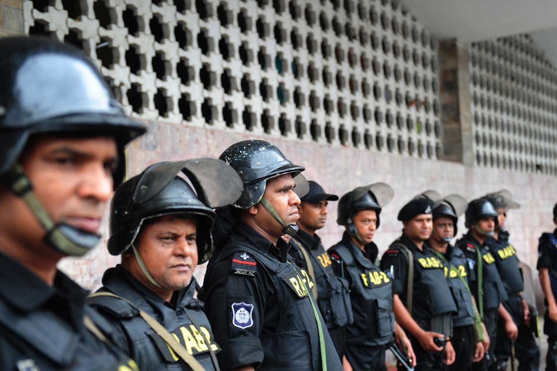 Rapid Action Battalion personnel stand guard following a clash between police and Islamists, in Dhaka on May 6, 2013.  