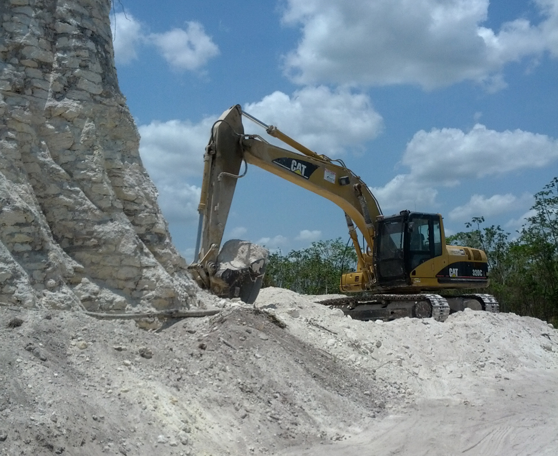 In this image released by Jaime Awe, head of the Belize Institute of Archaeology on Monday May 13, 2013, a backhoe claws away at the sloping sides of the Nohmul complex, one of Belize's largest Mayan pyramids on May 10, 2013 in northern Belize.