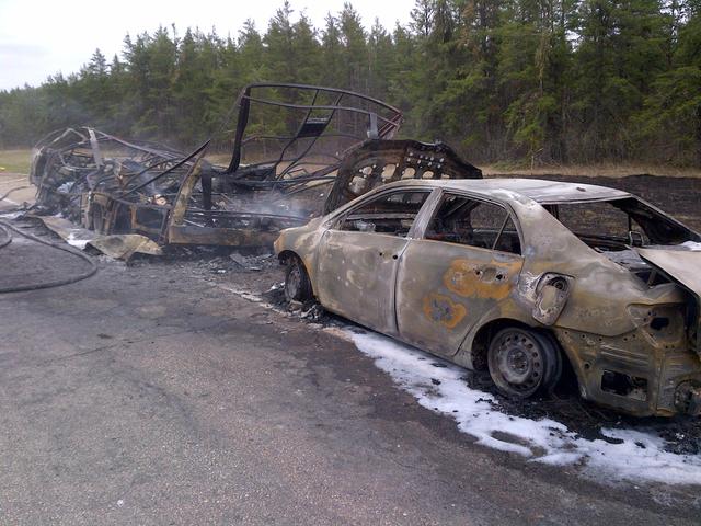 The charred shell of a motorhome and the vehicle it was towing sit on the shoulder of Highway 1 east of Spruce Siding, MB. Photo taken May 25, 2013.