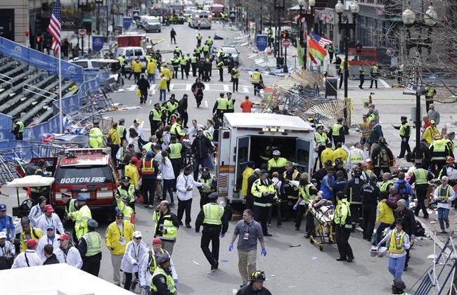 FILE - In this April 15, 2013 file photo, medical workers aid injured people at the finish line of the 2013 Boston Marathon following a bomb explosion in Boston, Monday, April 15, 2013. 