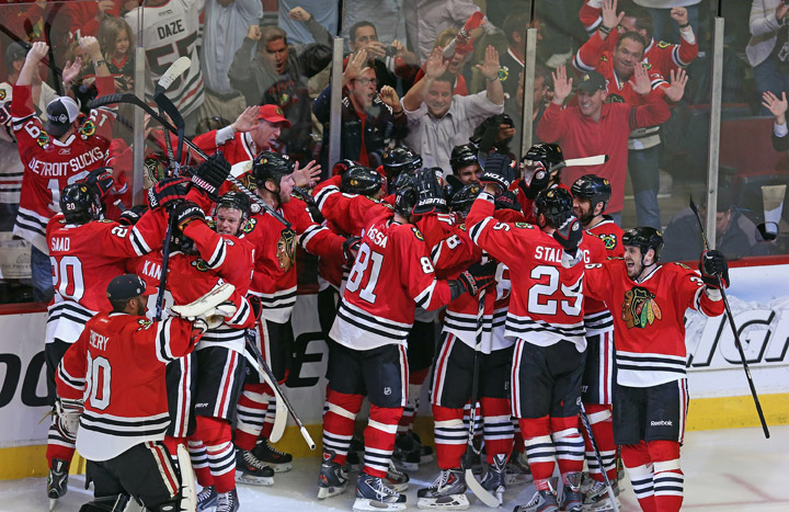 Members of the Chicago Blackhawks mob teammate Brent Seabrook after Seabrook scored the game-winning goal against the Detroit Red Wings in Game Seven of the Western Conference Semifinals during the 2013 NHL Stanley Cup Playoffs at the United Center on May 29, 2013 in Chicago, Illinois. The Blackhawks defeated the Red Wings 2-1 in overtime.