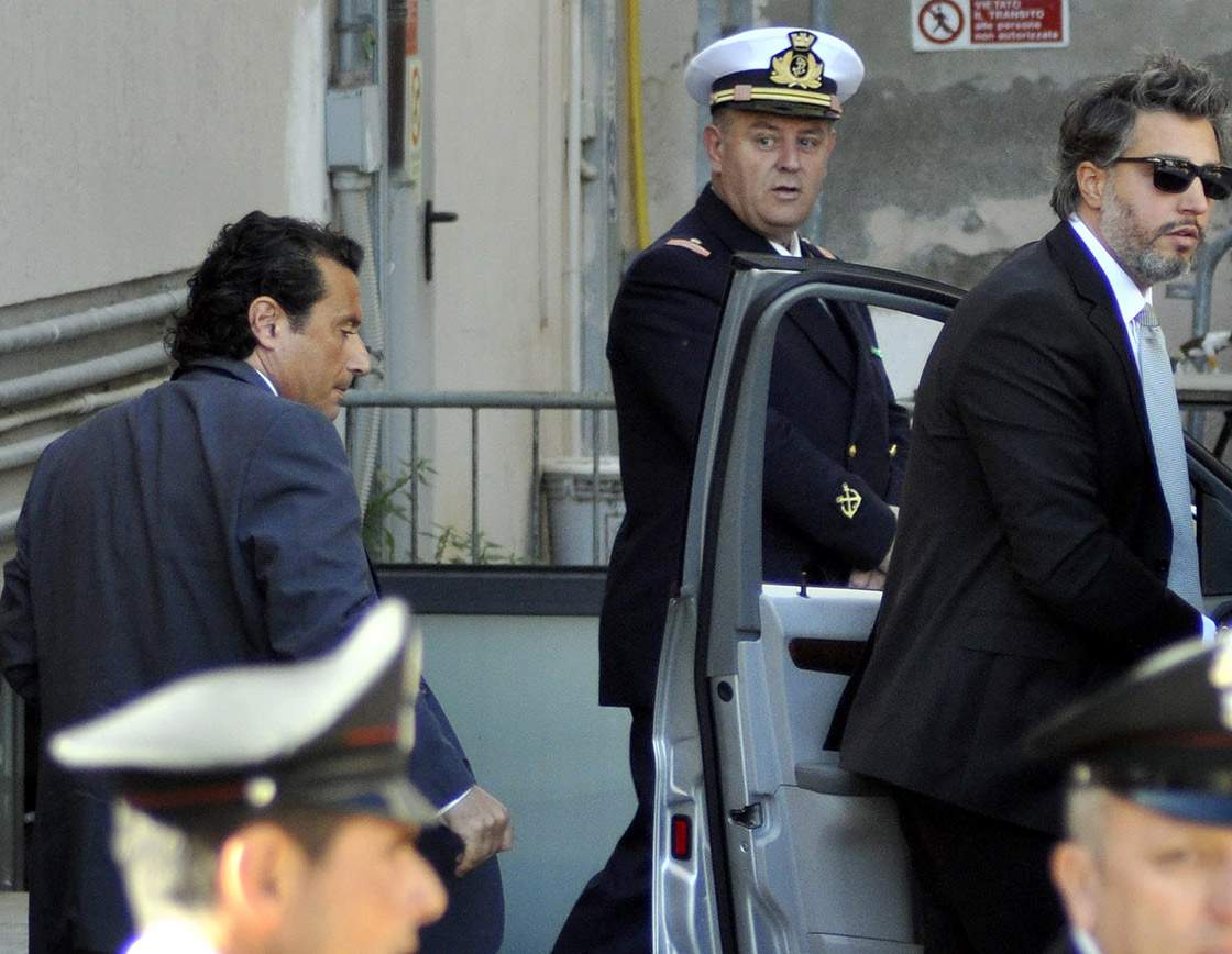 Former captain of the Costa Concordia luxury cruise ship Francesco Schettino, left, arrives with his lawyer Francesco Pepe, right, for a closed-door hearing for the 2012 grounding off Tuscany that killed 32 people, in Grosseto, Italy, Tuesday, May 14, 2013.
