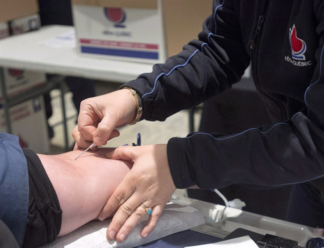 A man gives blood in Montreal, Thursday, November 29, 2012.A new study suggests that offering incentives to blood donors may alter the proportion of people who are willing to roll up their sleeves.