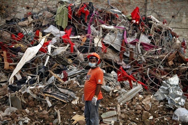 A Bangladeshi rescuer stands amid the rubble of a garment factory building that collapsed on April 24 as they continue searching for bodies in Savar, near Dhaka, Bangladesh, Sunday, May 12, 2013. 
