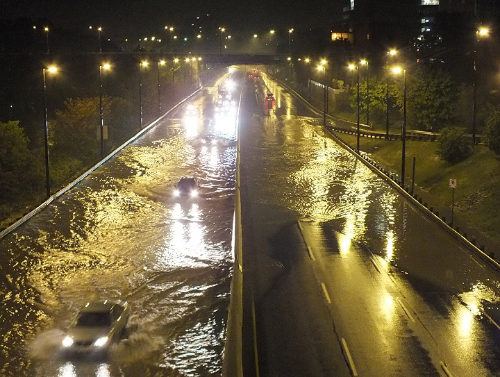 Motorists slowly make their way through the flooded DVP.