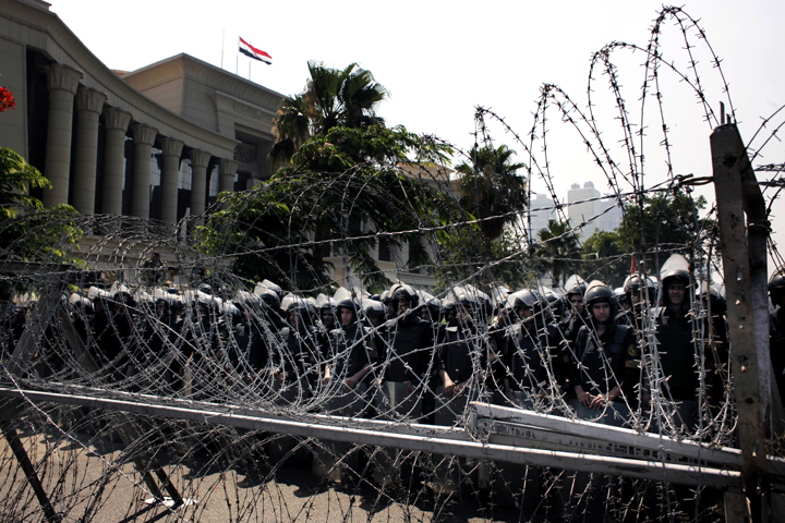 FILE - In this Thursday, June 14, 2012 file photo, Egyptian soldiers stand guard during a protest in front the Supreme Constitutional Court, Egypt's highest court, background, in Cairo, Egypt.