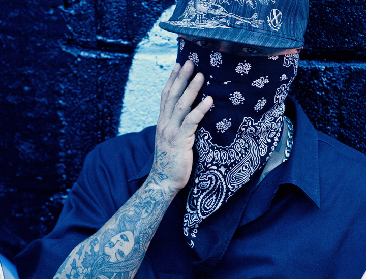 A masked member of the 18th Street gang, touches his mask during a press conference inside the San Pedro Sula prison in Honduras, Tuesday, May 28, 2013.  