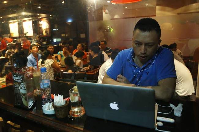 A Vietnamese man uses a laptop to go online by a 3G device inserted into a USB pot at a cafe in Ha Noi, Viet Nam on Wednesday, May 14, 2013. Close to a third of Vietnam’s 90 million people are online and men and women browsing phones and tablets are ubiquitous in the cafes of its towns and cities. The country’s potential for growth, young population and good Internet infrastructure have made it an attractive destination for regional and international investors and startups in content provision, e-payment and other services. 