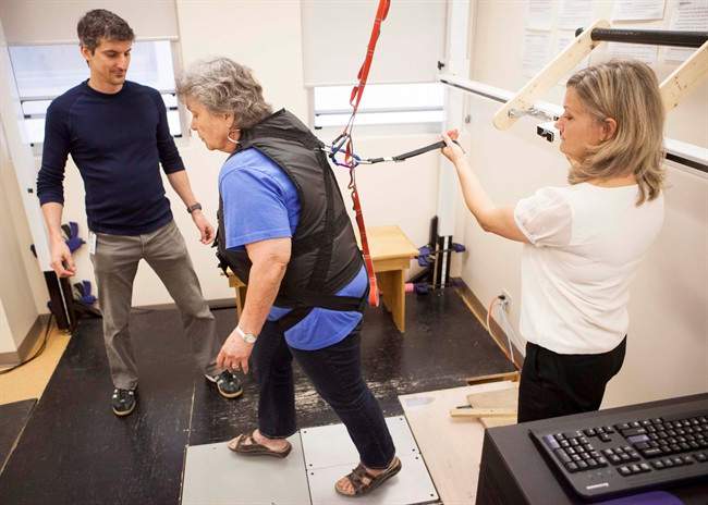 Stroke survivor Janet Raymond (centre) is helped by physiotherapist Lou Biasin (left) and Clinical Leader of the Balance and Mobility Clinic Liz Inness in performing exercises in a lean and release balance assessment tool at Toronto Rehab, Thursday, May 23, 2013. Raymond’s stroke didn’t only affect one side of her body, it affected her whole life. Help came in the form of Toronto Rehab’s new Balance, Mobility and Falls Clinic.