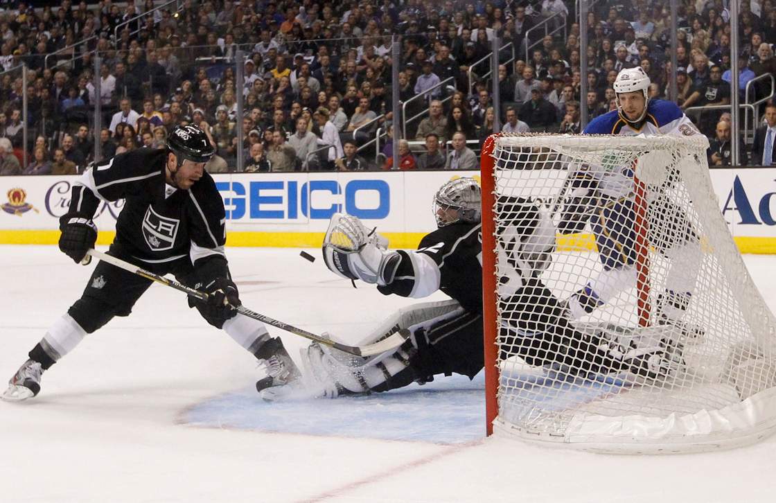 Los Angeles Kings goalie Jonathan Quick, center, stops a shot as Kings' Rob Scuderi, left, and St. Louis Blues' Chris Stewart watch during the third period in Game 3 of a first-round NHL hockey Stanley Cup playoff series in Los Angeles, Saturday, May 4, 2013. The Kings won 1-0. 