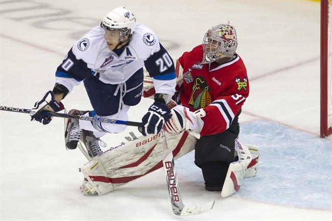 Saskatoon Blades right winger Josh Nicholls trips over the extended pad of Portland Winterhawks goaltender Mac Carruth during the second period of Memorial Cup action in Saskatoon, Sask. on Wednesday, May 22, 2013.
