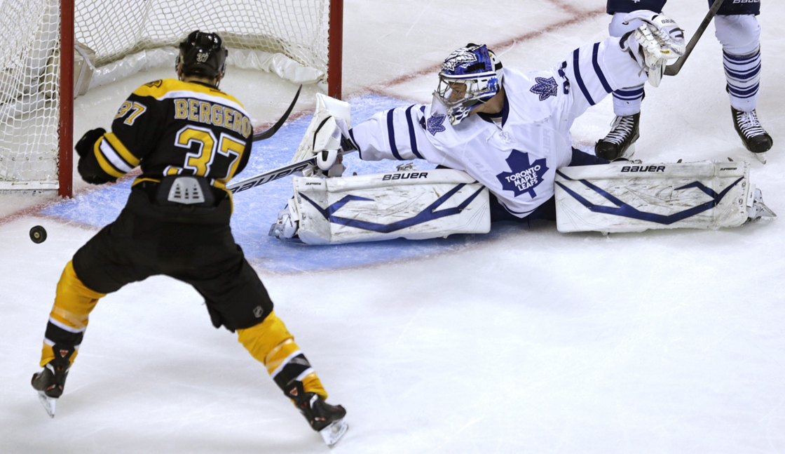 Toronto Maple Leafs goalie James Reimer, right, spreads to make a save on a shot by Boston Bruins center Patrice Bergeron (37) during the second period in Game 5 of an NHL hockey Stanley Cup playoff series, in Boston on Friday, May 10, 2013.
