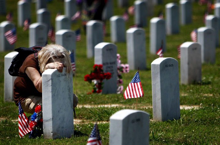 Magdalena Crews weeps at the grave of her husband, Gene Wesley Crews Sr., at the West Tennessee State Veterans Cemetery in Germantown, Tennessee.  