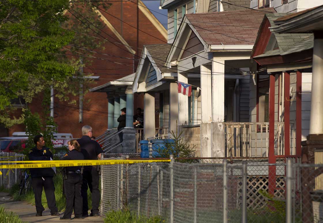 Cleveland Police stand outside a home where they say missing women, Amanda Berry, Gina DeJesus and Michele Knight were found in the 2200 block of Seymour Avenue in Cleveland on Monday, May 6, 2013.