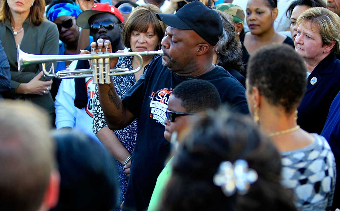 A man plays the trumpet on the corner of North Villere and Frenchman Street during a community response to a shooting during a Mother's Day parade, on May 13, 2013 in New Orleans, Louisiana. 