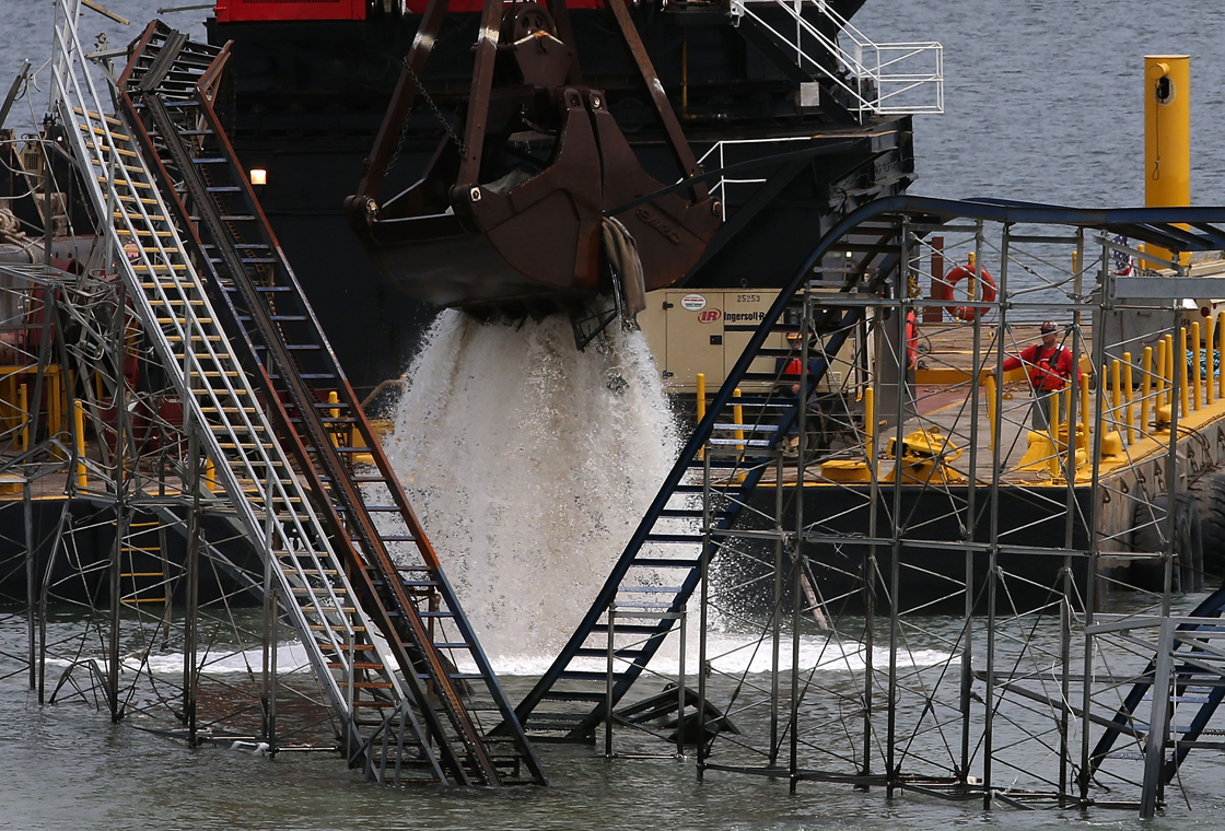 A large crane demolishes the JetStar roller coaster that has been in the ocean for six months after the Casino Pier it sat on collapsed when Superstorm Sandy hit, May 14, 2013 in Seaside Heights, New Jersey. 