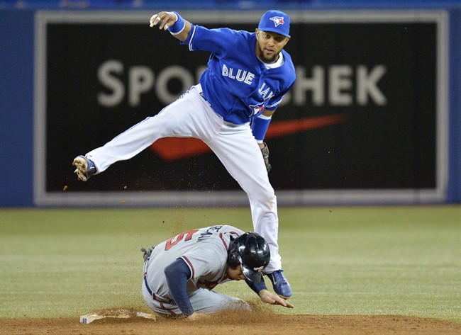 Toronto Blue Jays shortstop Maicer Izturis, top, forces out Atlanta Braves Freddie Freeman, bottom, at second base then turns the double play to get Braves catcher Evan Gattis at first during third inning interleague baseball action in Toronto on Tuesday, May 28, 2013. THE CANADIAN PRESS/Nathan Denette.