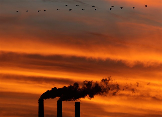 In this Sunday, Dec. 2, 2012 photo, a flock of Geese fly past the smokestacks at the Jeffrey Energy Center coal power plant as the suns sets near Emmett, Kansas.