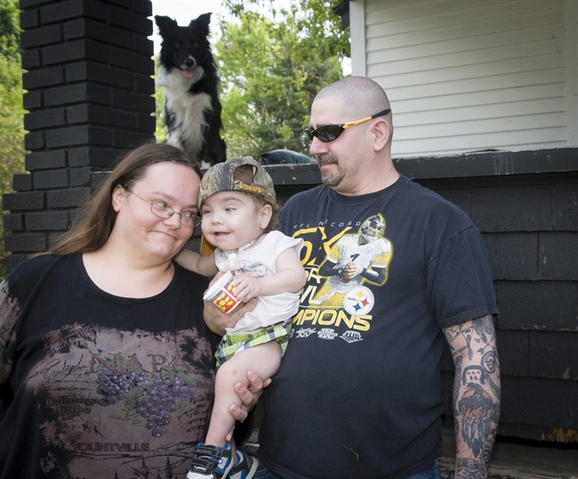 Kaiba Gionfriddo is hugged by his parents April and Bryan outside their Youngstown, Ohio home Tuesday, May 21, 2013. Born with a birth defect that caused the boy to stop breathing every day, he can now breathe normally, with a first-of-a-kind biodegradable airway made by Michigan doctors using plastic particles and a 3-D laser printer.