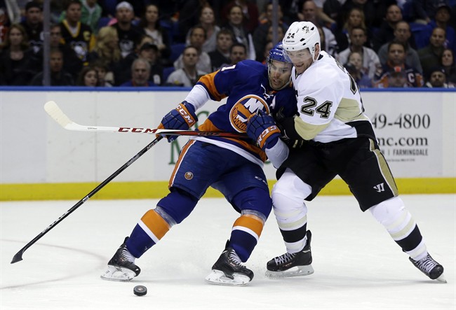 Pittsburgh Penguins’ Matt Cooke, right, takes down New York Islanders’ John Tavares during the third period of Game 3 of an NHL hockey Stanley Cup first-round playoff series on Sunday, May 5, 2013, in Uniondale, N.Y. (Seth Wenig / AP Photo)
