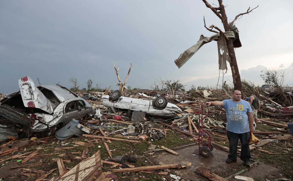 A man stands in the rubble of his house after a powerful tornado ripped through the area on May 20, 2013 in Moore, Oklahoma. The tornado, reported to be at least EF4 strength and two miles wide, touched down in the Oklahoma City area on Monday killing at least 51 people. 