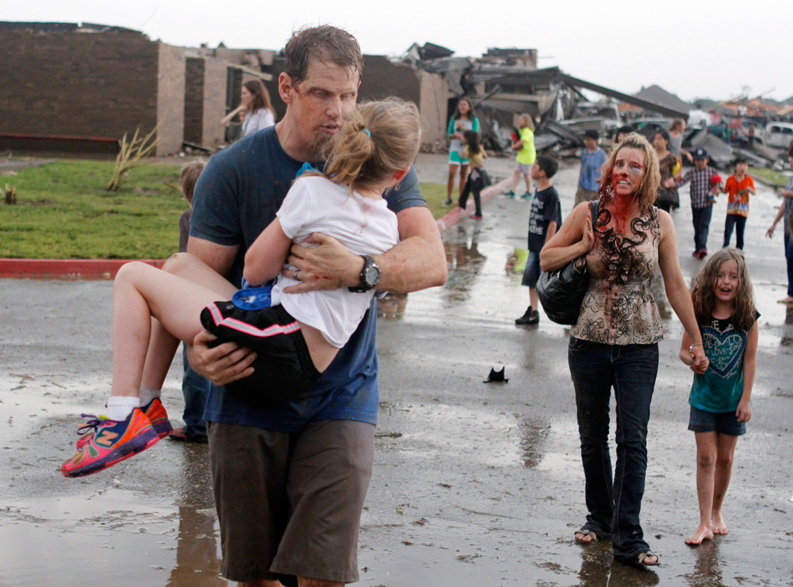 Teachers carry children away from Briarwood Elementary school after a tornado destroyed the school in south Oklahoma City, Monday, May 20, 2013.