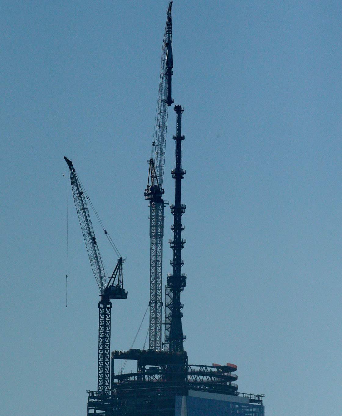 A crane lifts into place a 408-foot spire at the top of One World Trade Center seen from the Heights neighborhood of Jersey City, N.J., Friday, May 10, 2013.