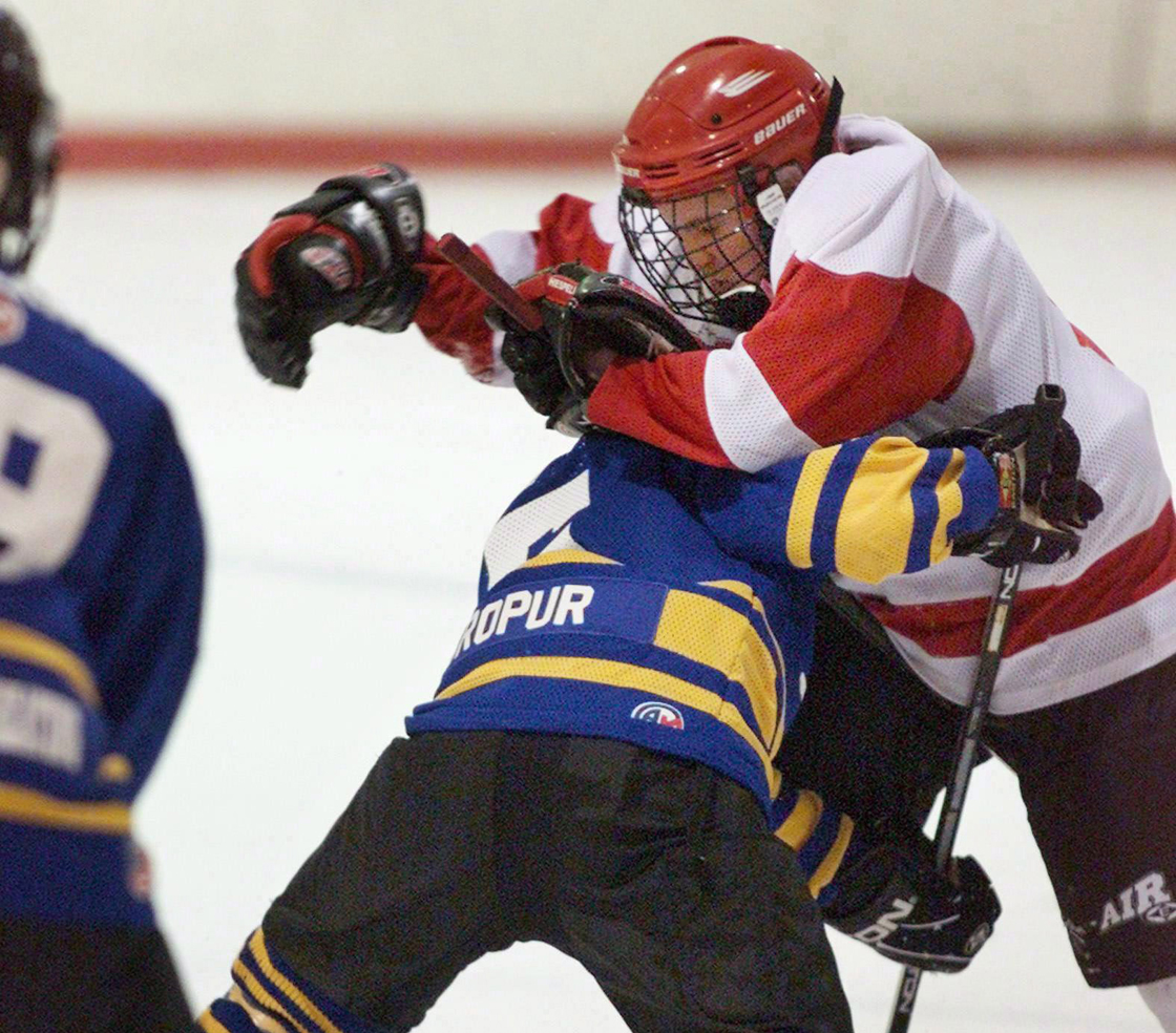File - A player from the Dartmouth Whalers collides with a member of the Cole Harbour Red Wings, right, in peewee "A" action in Halifax on Thursday Feb. 15, 2001. 