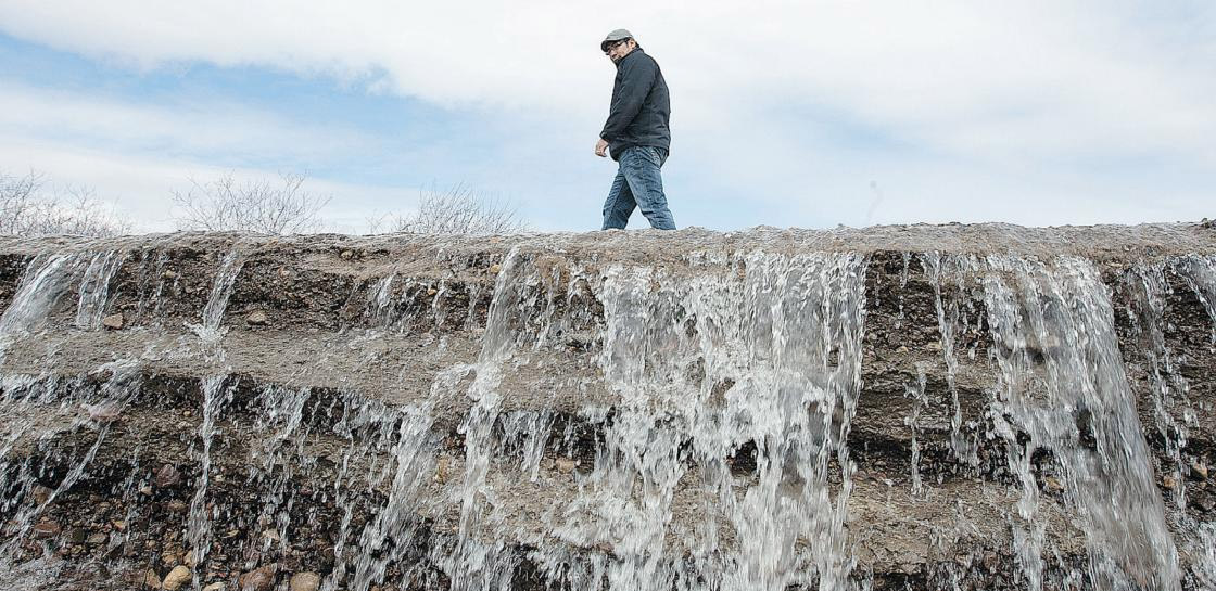 Clifton Okemaysim, assistant director of public works for the Onion Lake First Nation, walks on a road being overrun by flood waters last Thursday. 13 people have now been forced from their homes due to a grass fire at the First Nation that is also under a flood threat.