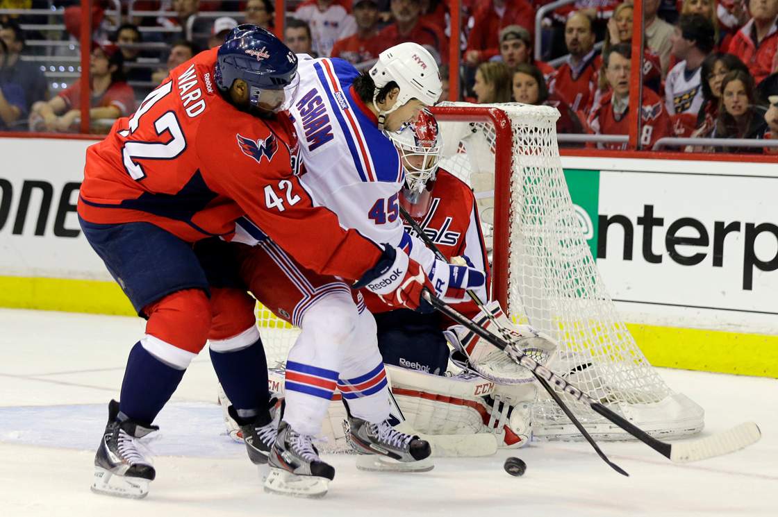 Washington Capitals right wing Joel Ward (42) guards New York Rangers right wing Arron Asham (45) as he works in front of goalie Braden Holtby (70) in the third period of Game 5 first-round NHL Stanley Cup playoff hockey series, Friday, May 10, 2013, in Washington. 