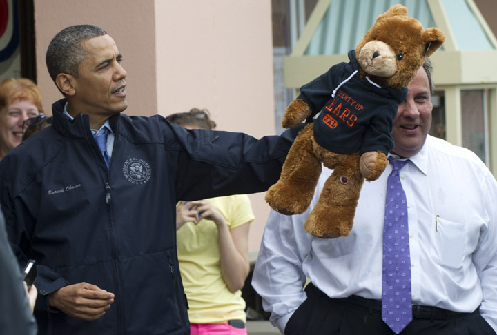Obama holds a stuffed bear alongside New Jersey Governor Chris Christie after playing an arcade game along the boardwalk as they view rebuilding efforts following last year's Hurricane Sandy in Point Pleasant, New Jersey, on May 28, 2013.
