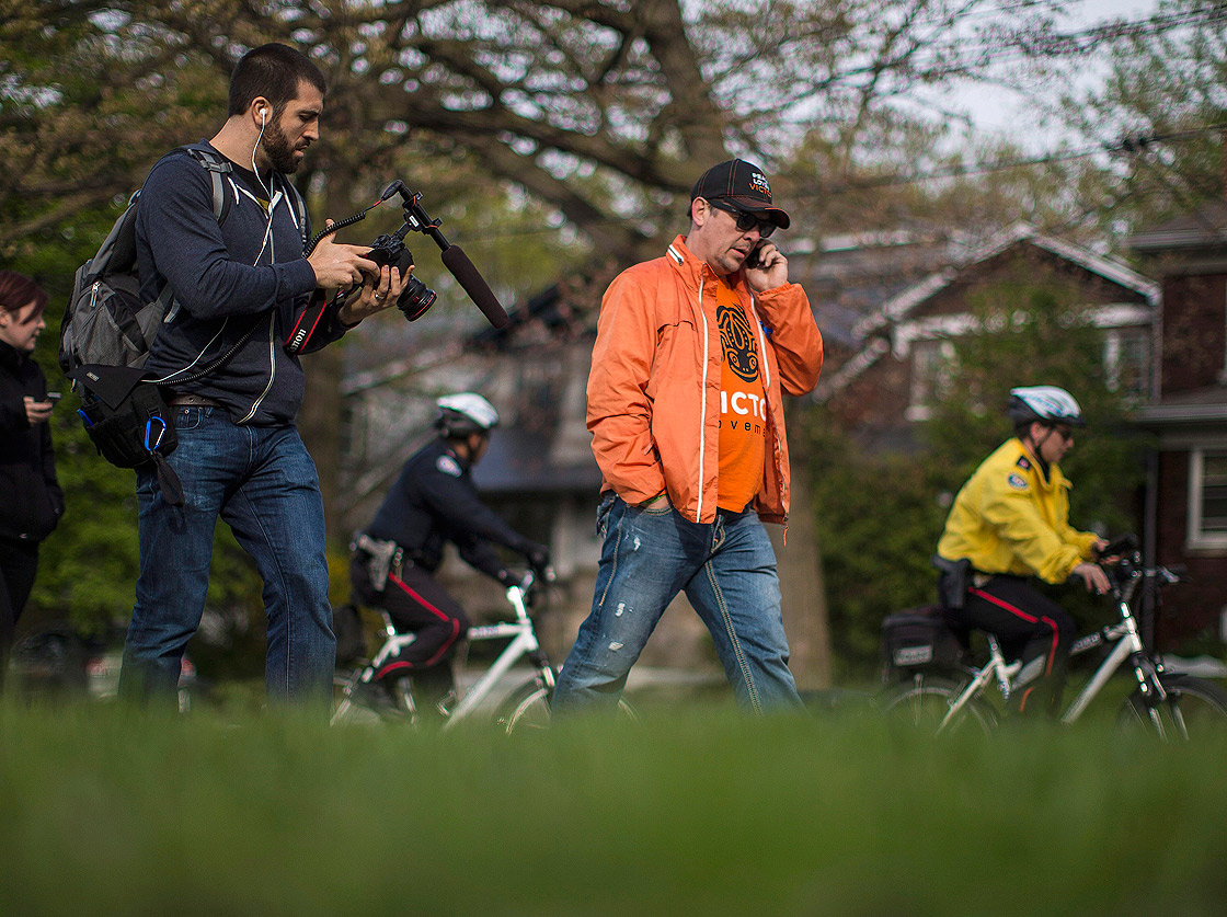 Former NHLer Theoren Fleury takes a phone call as he begins “The Victor Walk” in Toronto on Tuesday May 14, 2013