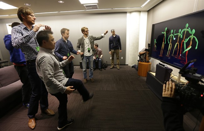A group of visiting journalists try out the improved motion-detecting capabilities of the new Kinect controller for Microsoft's next-generation Xbox One entertainment and gaming console system, Tuesday, May 21, 2013, in Redmond, Wash. The new Kinect, which will come standard with the Xbox One can also see users in total darkness and has a wider field of view than the previous Kinect device in use with the Xbox 360. 