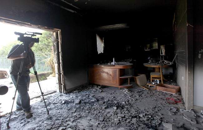 FILE - This Sept. 13, 2012 file photo shows a cameraman filming one of U.S. consulate burnt out offices after an attack that killed four Americans, including Ambassador Chris Stevens on the night of Tuesday, Sept. 11, 2012, in Benghazi, Libya.