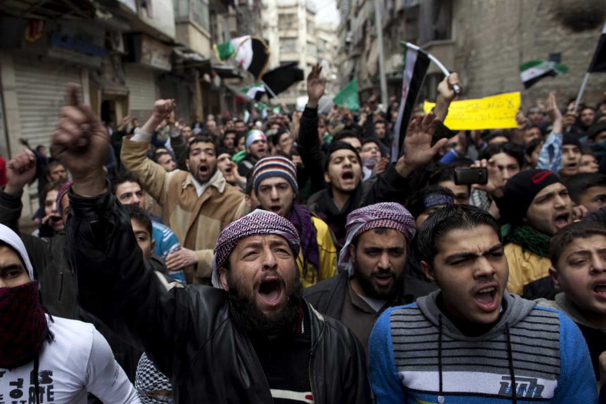 Syrians shout slogans during the funeral of civilians, who were executed and dumped in the Quweiq river, in the Bustan al-Qasr district of the northern city of Aleppo on January 31, 2013. The bodies of more than 80 young men, all executed with a single gunshot, were found in the river on Jan. 29.