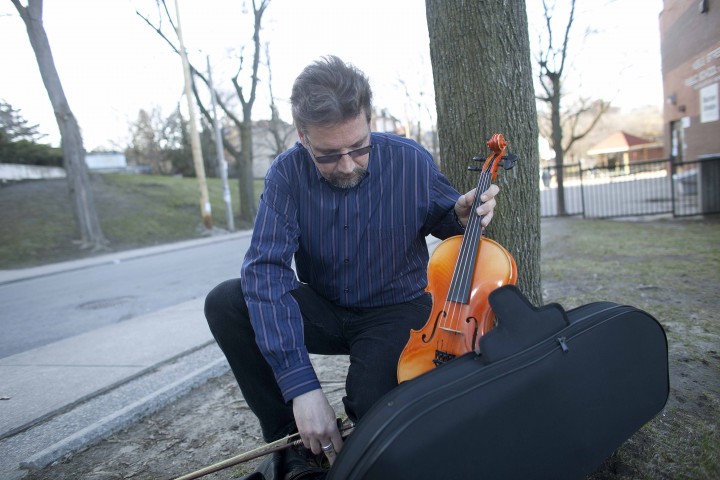 Strings instructor David Spek outside Keele St. Public School, with his viola. He is spearheading effort to save music teacher jobs at TDSB, board issuing layoff notices Thursday.