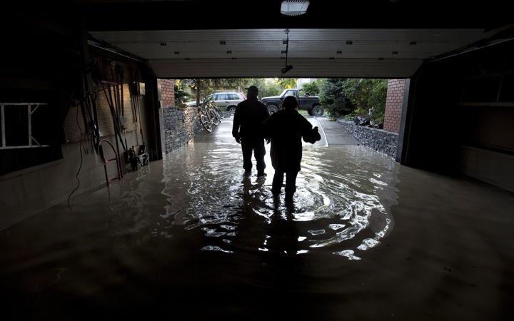 A couple is silhouetted as they walk out of their flooded garage near the Elbow River in Calgary, Ab. Saturday, June 22, 2013. 