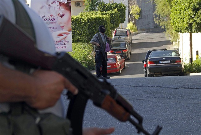 File: Gunmen and followers of a radical Sunni cleric Sheik Ahmad al-Assir block a road, in the southern port city of Sidon, Lebanon, Tuesday, June 18, 2013.