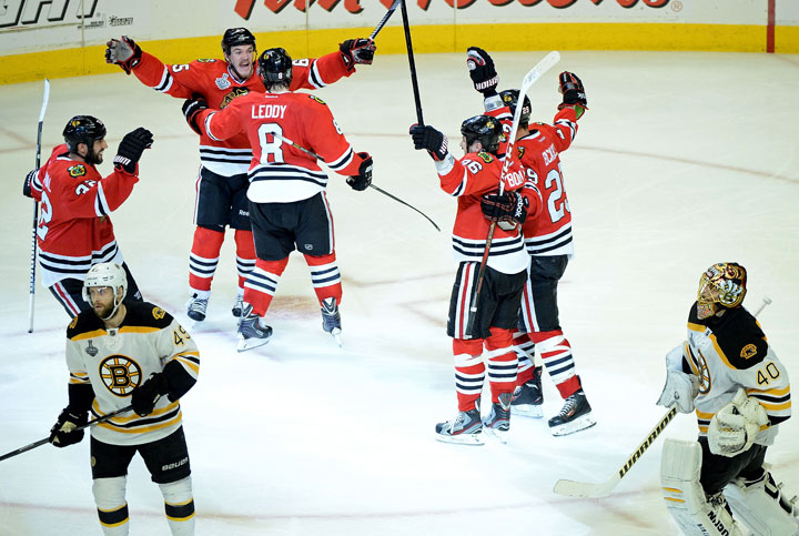 Andrew Shaw and Nick Leddy of the Chicago Blackhawks celebrate with their teammates as Rich Peverley and goalie Tuukka Rask of the Boston Bruins skate off of the ice after Shaw scored the game-winning goal in the third overtime to give the Blackhawks a 4-3 win in Game 1 of the 2013 NHL Stanley Cup Final at United Center on June 12, 2013 in Chicago, Illinois. Harry How/Getty Images