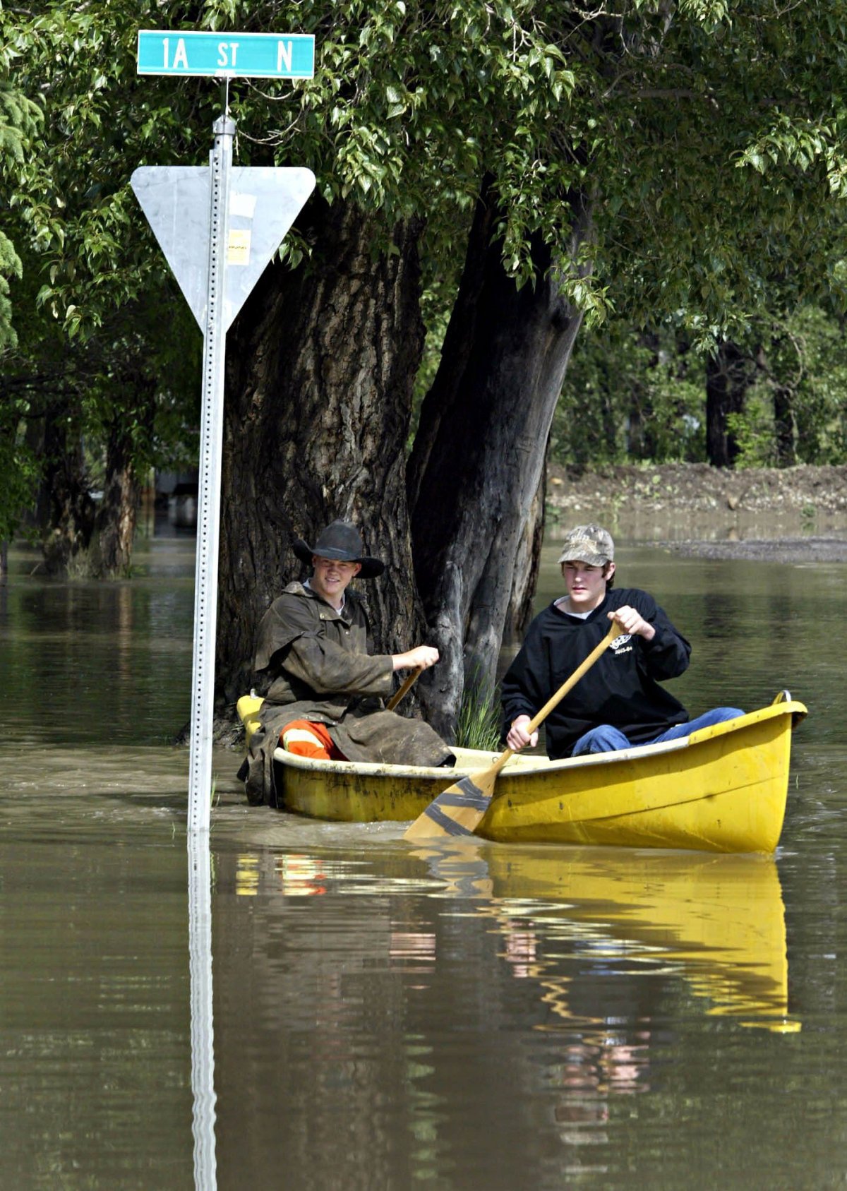 Aaron Ferguson, 17, right, and Mike Weeks, 18, paddle through flood waters in a High River, Alta., community on Wednesday, June 8, 2005. A section of the southern Alberta town was evacuated on Tuesday following a week of heavy rains  and residents are slowly being allowed back into their homes Wednesday.