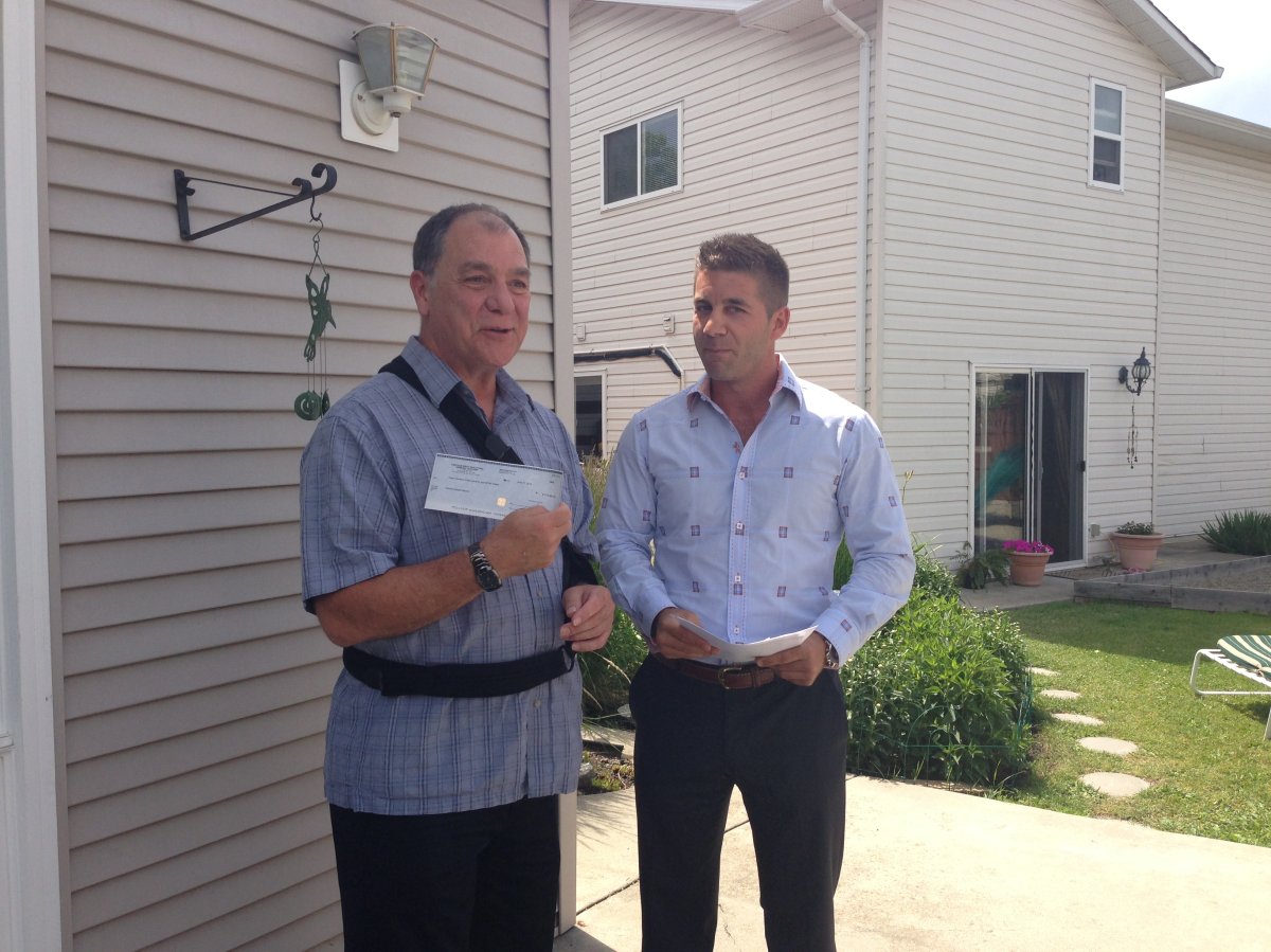 Kelowna Gospel Mission Exec. Director Randy Benson graciously accepts a cheque from Vantage West Realty.