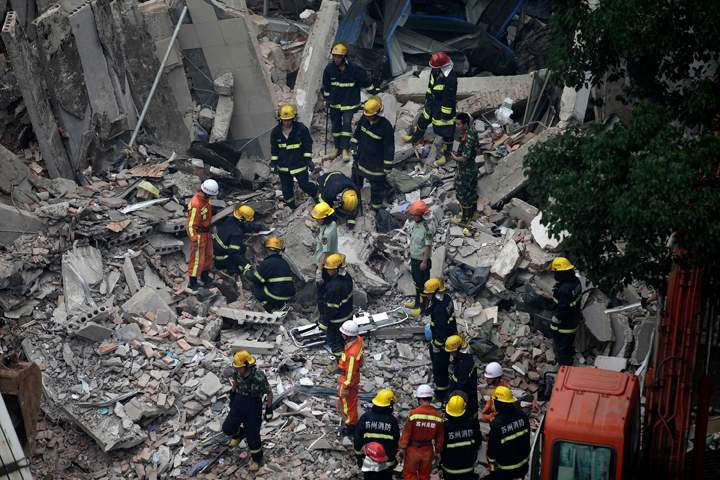 Rescuers search for buried people under the ruins of a building on June 11, 2013 in Suzhou, China. 