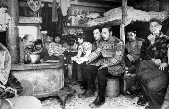 Jackie Vautour (bald, behind the stove) talks strategy with friends in his tiny hut in Kouchibouguac National Park, N.B. on April 3, 1980.